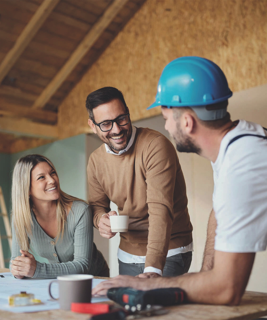 couple heureux qui discute avec un conducteur de travaux sur leur projet de construction