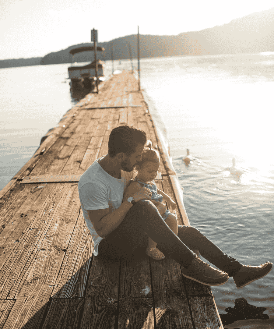 pere et fille sur un ponton devant un lac