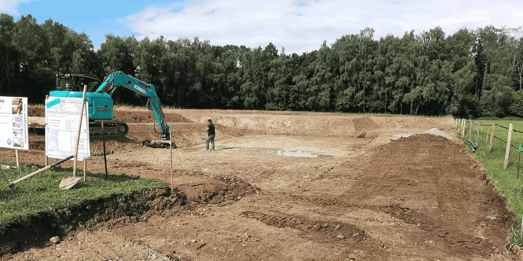 photo homme debout sur un debut de chantier autour de beaucoup de terre