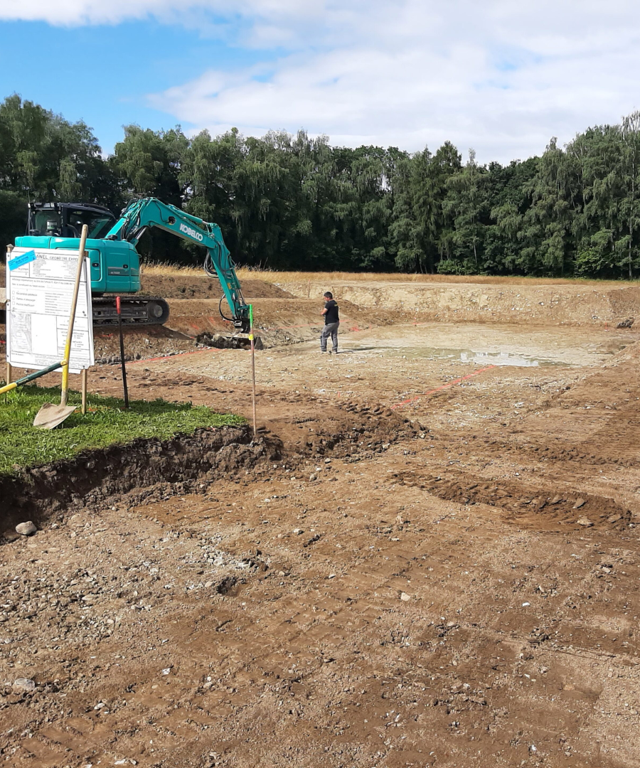 photo homme debout sur un debut de chantier avec beaucoup de terre